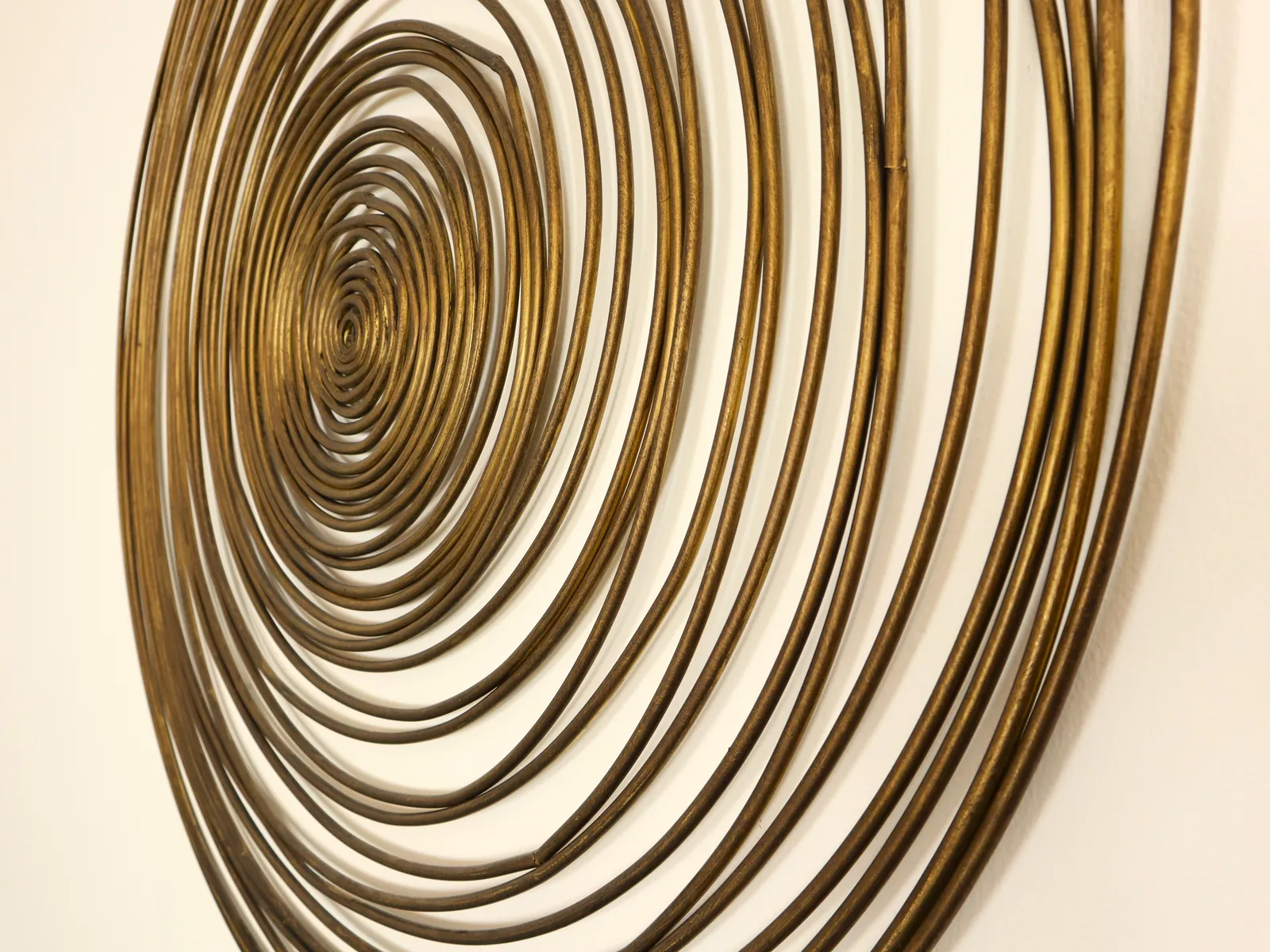 Detail der goldfarbenen Wandspirale in der Praxis.